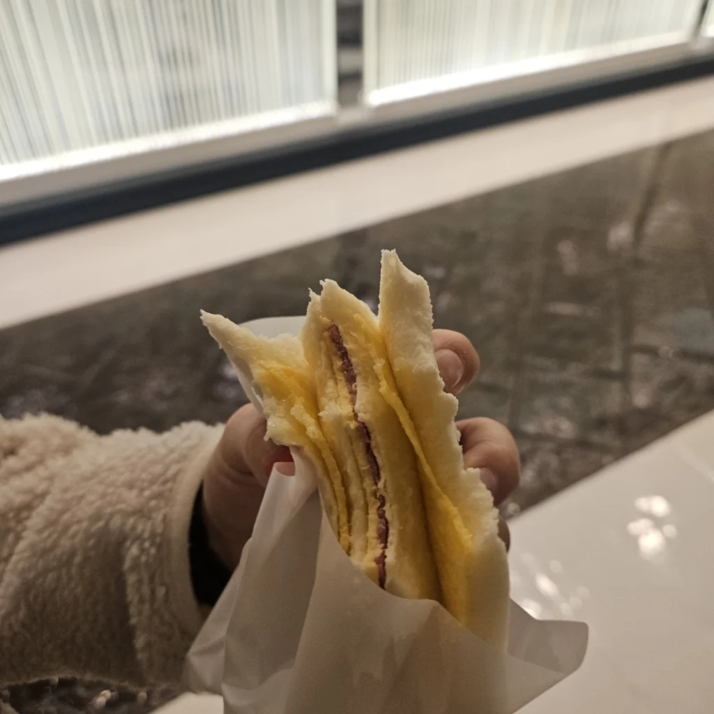 손에 홍루이젠 샌드위치를 들고있는 사진