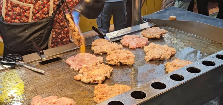 불판위에서 토치로 닭고기를 구워내고 있는 사진